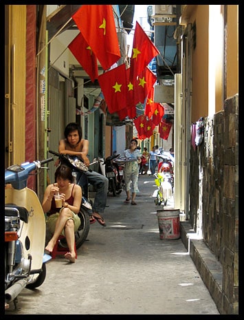 An alley riddled with flags of Vietnam.