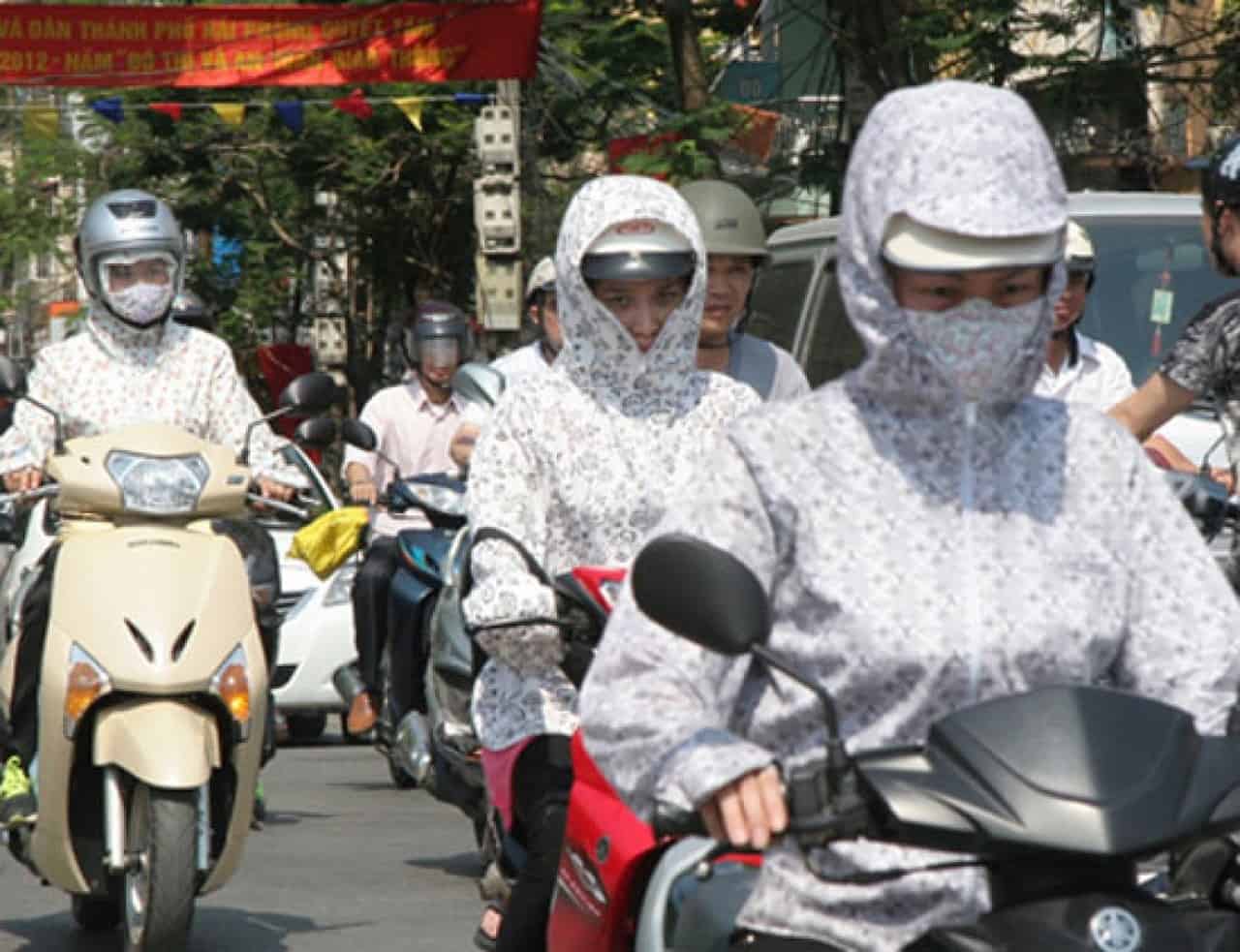Vietnamese motorbike drivers shielded from the sun