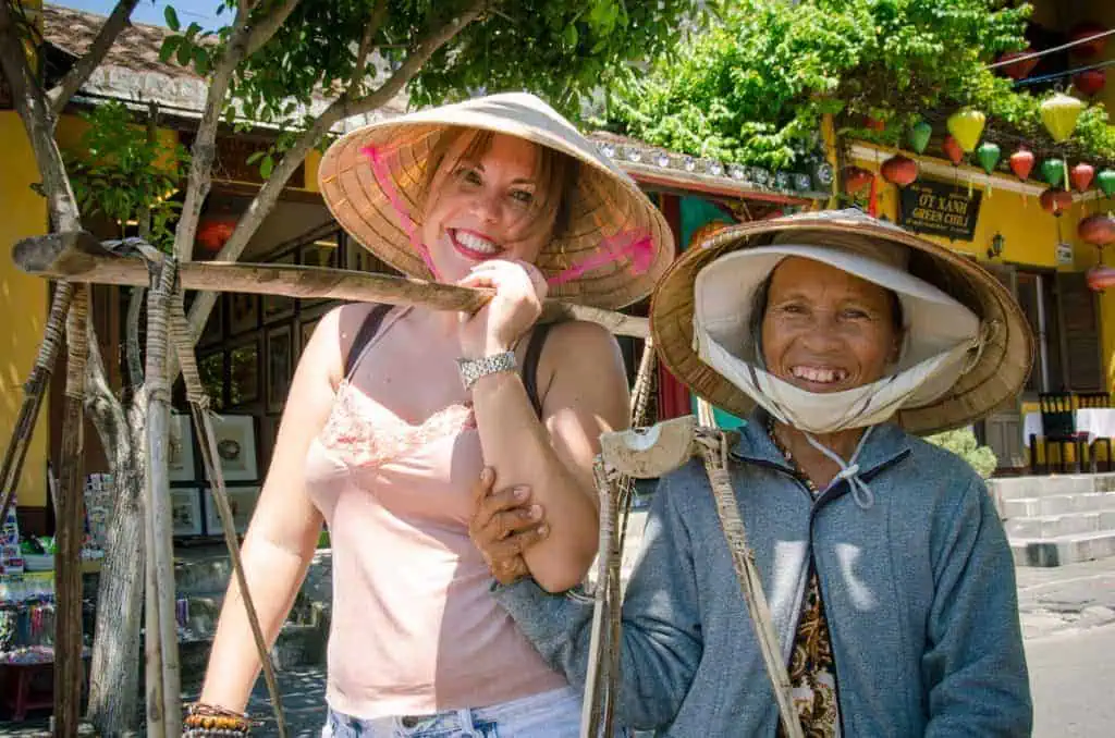 Smiling Female tourist enjoy with Ho An friendly local street seller 