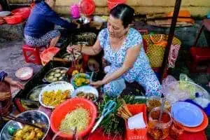 A street food vendor in Saigon with all of her ingredients laid out around her.